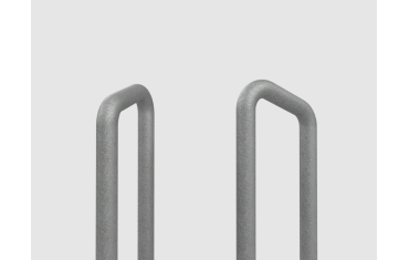 a bent metal hand grab rail. the rail is made from one continuous piece of metal bent at two angles to create two vertical posts and an angled hand grab.
